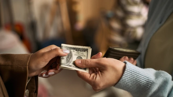 customer handing over cash to business owner