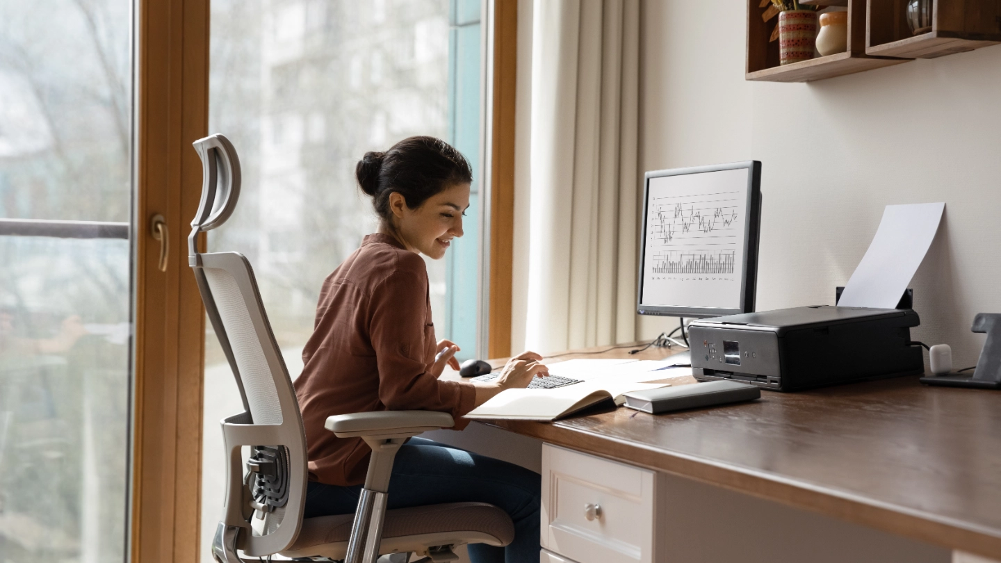 woman behind desk working on a computer image